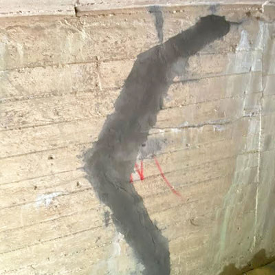 Concrete Crack repaired by injecting with epoxy and polyurethane products and applying trowel mortar to smaller spall areas