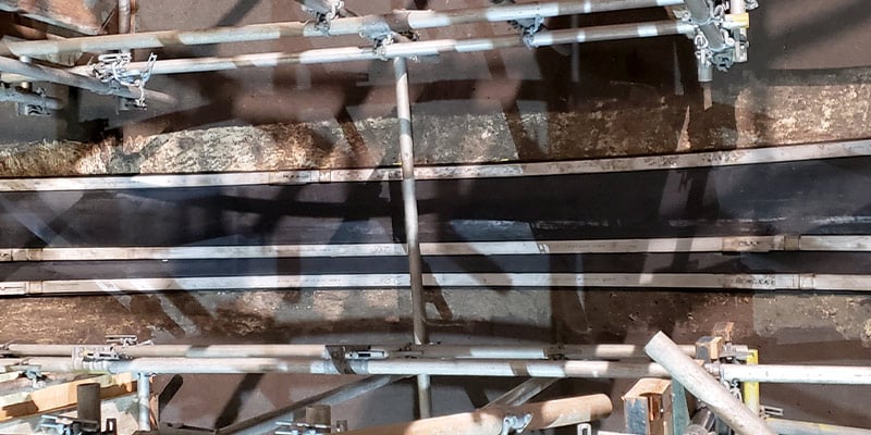 A large HydraTite seal applied to a pipe joint surrounded by scaffolding