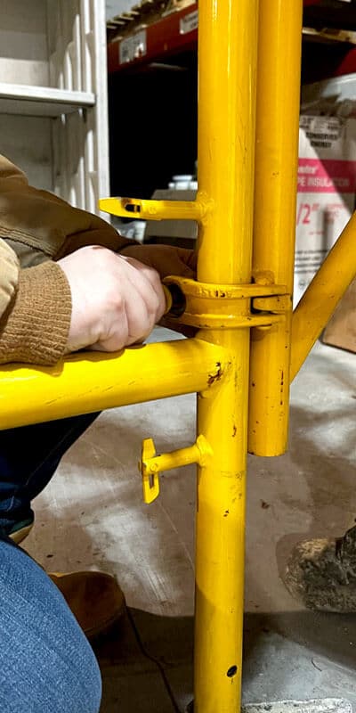 loosening a bolt on the scaffolding