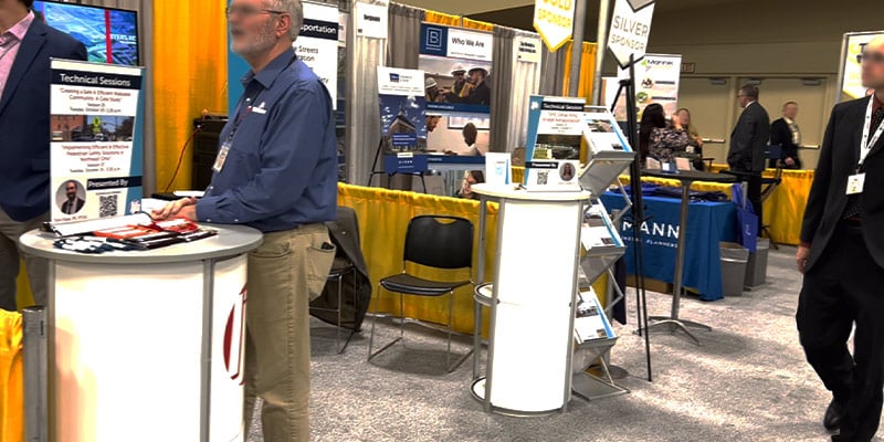 people walking around the OTEC conference and the booths they are visiting