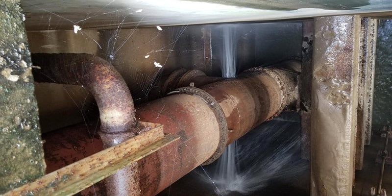 Water spraying out of a crack in a pipe