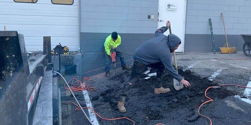 Two field techs removing old concrete