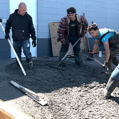 Three field workers working out the concrete