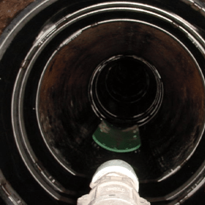 Looking down a dark pipe in which the joints have been sealed by HydraTite