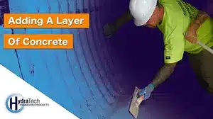 Technician applying concrete to the invert of a pipe