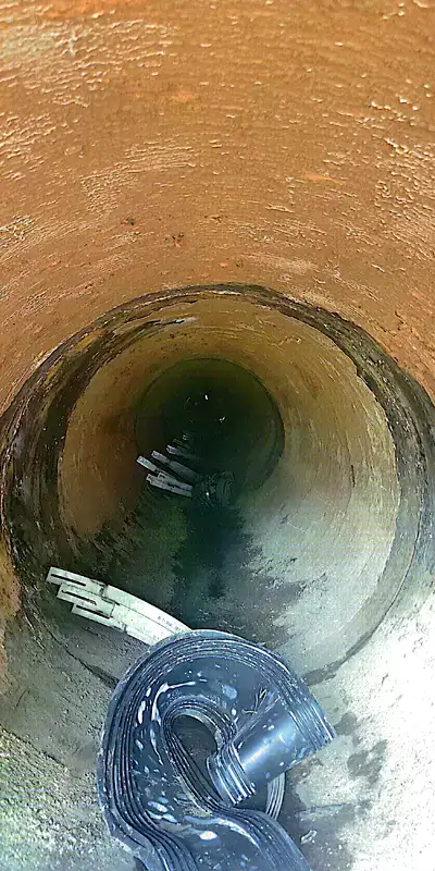 Invert of a pipe in which HydraTite seals are installed over a joint and neighboring fissures