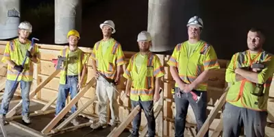 All our techs standing next to a wood frame to shape concrete