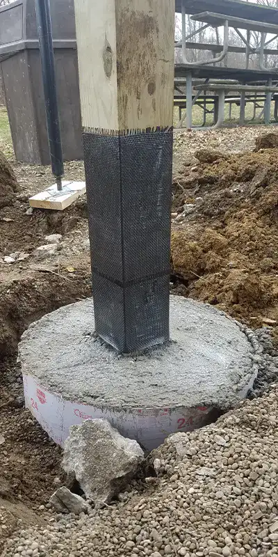 New concrete poured around the base of a pavilion post. A lower portion of the post has been reinforced with HydraWrap