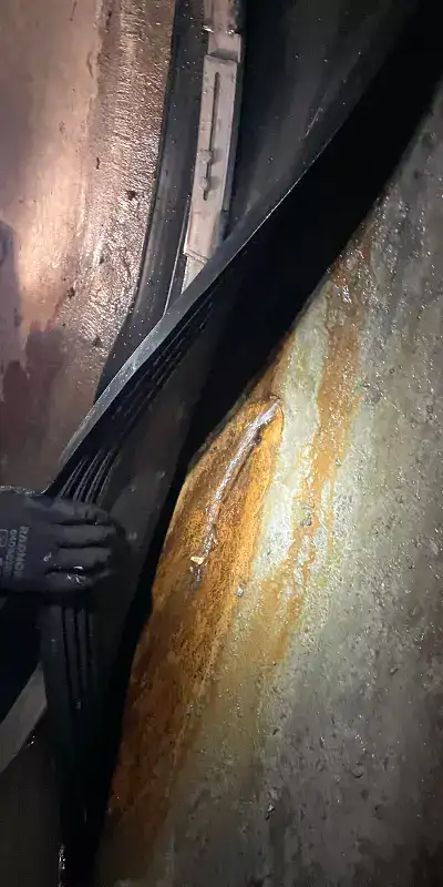 Pulling back the rubber to reveal an active leak