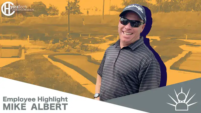 A guy standing in front of a mini golf course, 'Employee Highlight, Mike Albert'