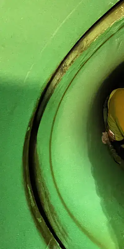 Interior view of an offset pipe joint in a green PVC pipe