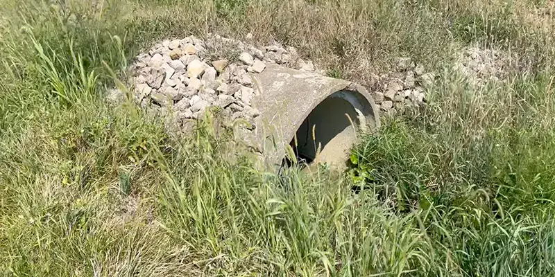 Joint with an active leak in a green PVC pipe