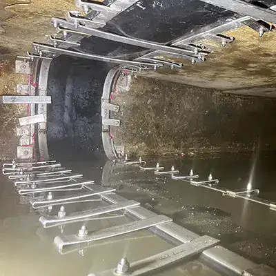 Two technicians installing HydraTite in a round pipe