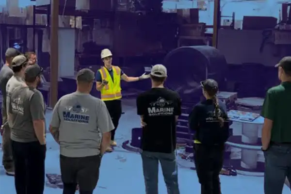 A group of people watching a HydraTite installation demonstration