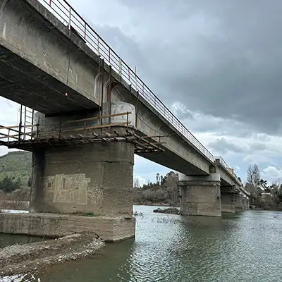 A bridge with failing joints running over a waterway