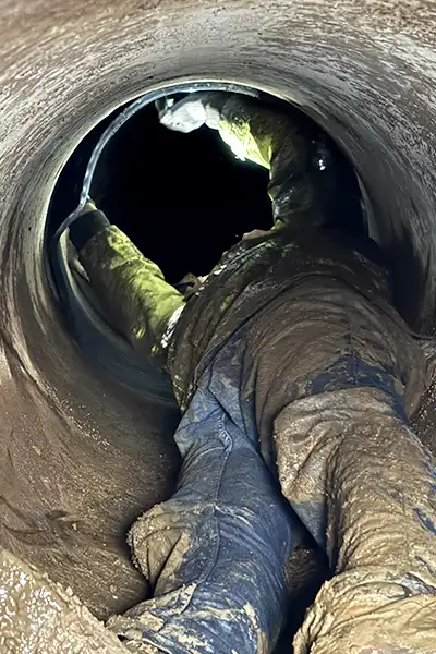 A technician deep in a tight pipe