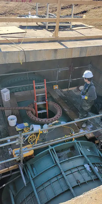 A technician standing near a pipe entry point