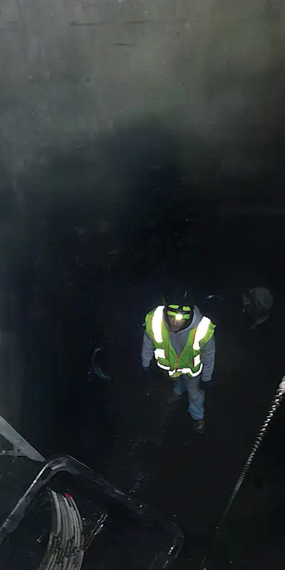 Looking down into a dark hole at a technician
