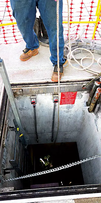Looking down into a pipe at a technician