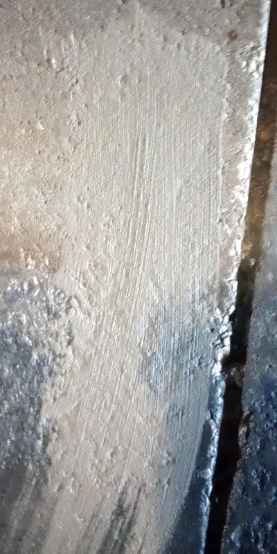 A concrete patch that has been applied to the interior of a pipe near a joint