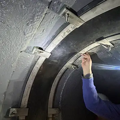 Inspecting a joint that has been restored with HydraTite in an arched tunnel aqueduct