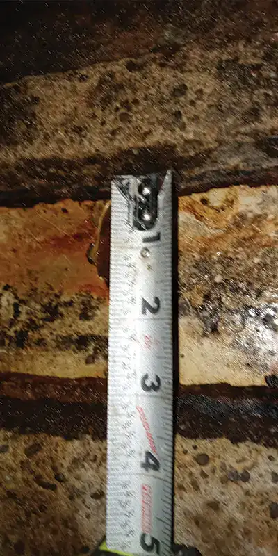 A measuring tape noting how separated a pipe joint is
