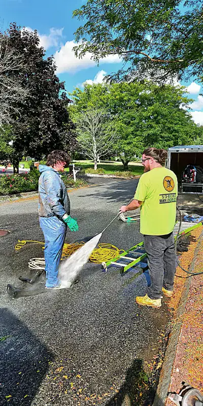A technician being sprayed off after climbing through a wastewater pipe