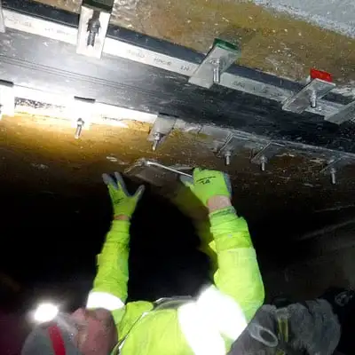 A technician installing HydraTite in a box-shaped aquaduct