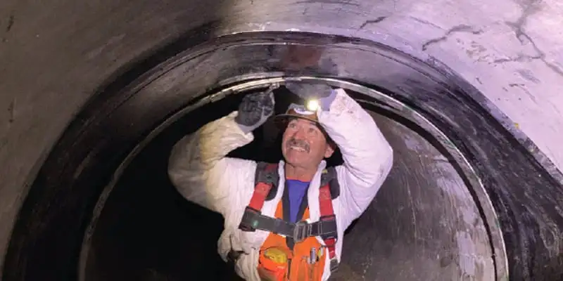 A field technician positioning the rubber under the steel band