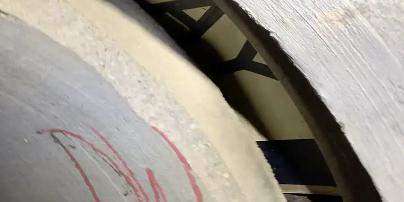 A severely separated pipe joint in which a traffic sign has been wedged to prevent more backfill from falling into the pipe