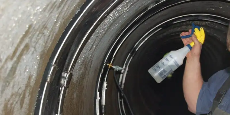 A spray bottle being used to conduct an air test on a HydraTite seal installation