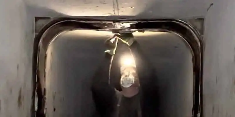 A technician positioning the first anchor and hold-down on a HydraTite installation in a box-shaped flume