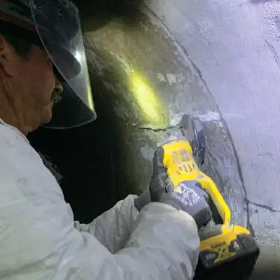 A close-up of a technician preparing the interior surface of the pipe for proper HydraTite installation