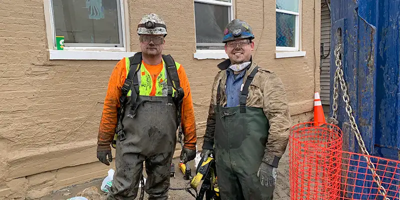 A couple technicians covered in mud