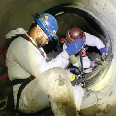 Two people installing HydraTite over a failing liner