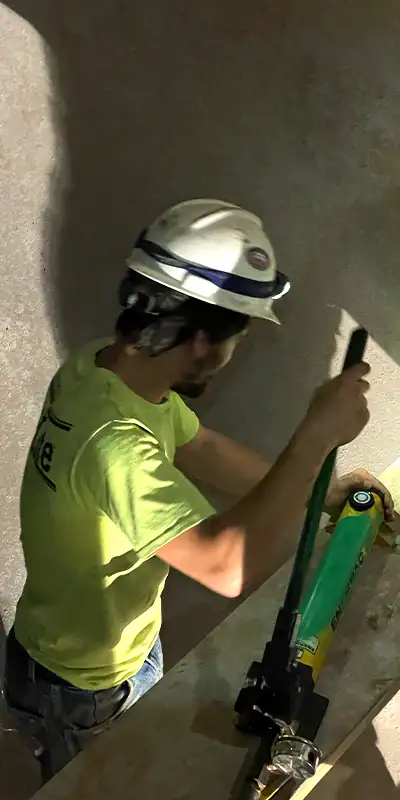 A technician pumping a hydraulic expander to install a HydraTite Internal Pipe Joint Seal over a joint in a pipe