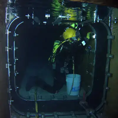 HydraTite being installed by a diver in a box-shaped chamber to prevent leaks