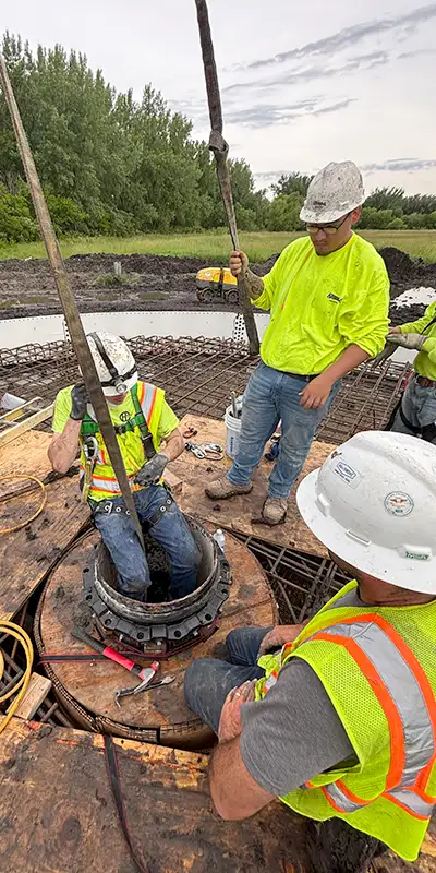 A technician preparing to enter a vertical pipe