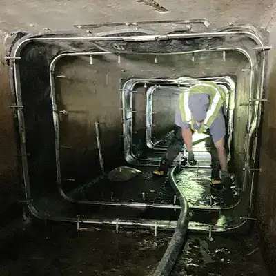 A technician working inside a box culvert to install HydraTite over the joints