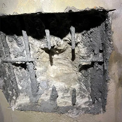 A portion of concrete removed from the interior wall of a pipe