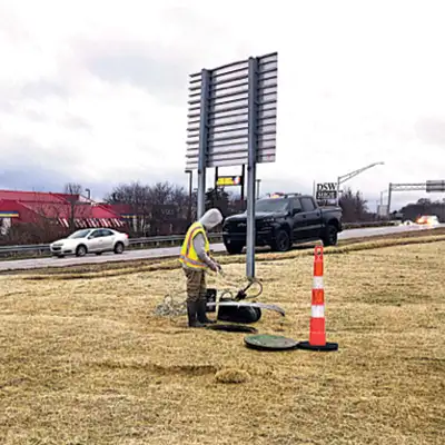 A field technician standing near a pipe entrance