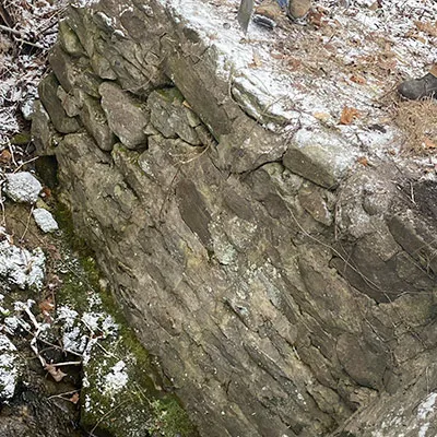 A damaged portion of headwall leading to a culvert