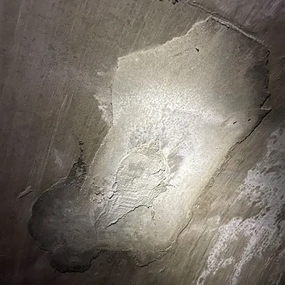 A patch of concrete applied to the interior of a pipe wall