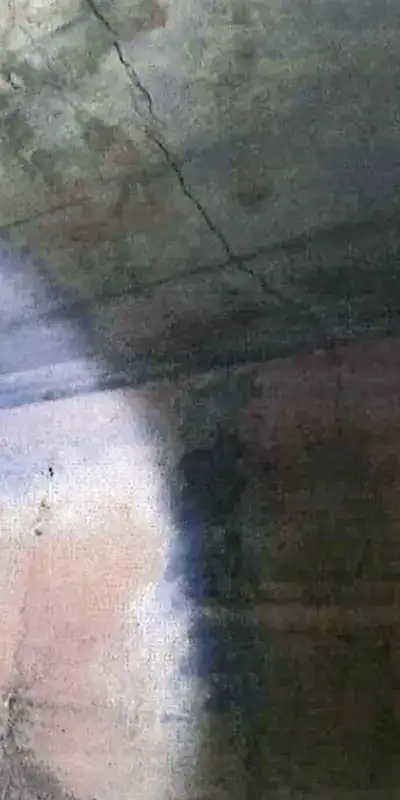 A damaged portion of the interior of a concrete box culvert