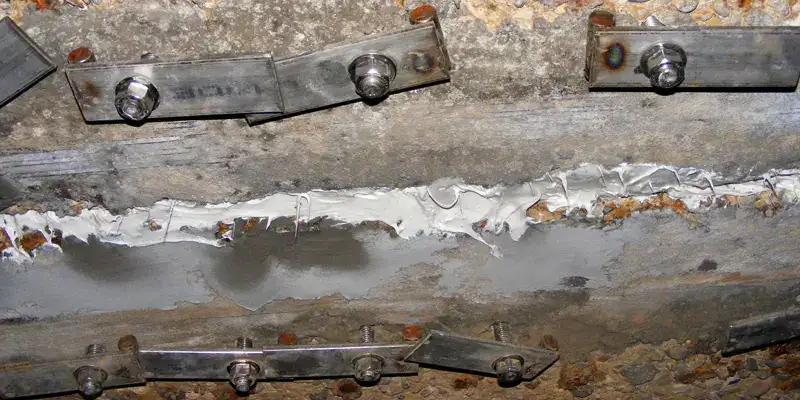 Anchors and hold downs installed on either side of a joint in a box-shaped trestle pipe