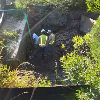 A few technicians standing at the entrance of a stormwater pipe