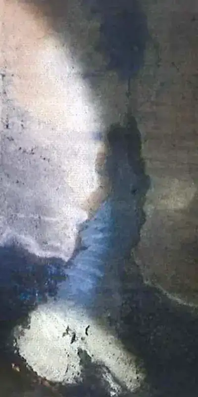 A damaged portion of the interior of a concrete box culvert