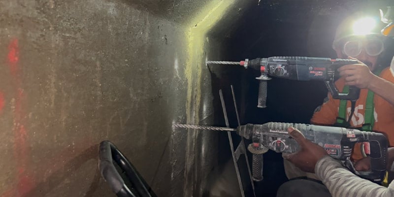 Technicians drilling holes in the walls of a box-culvert