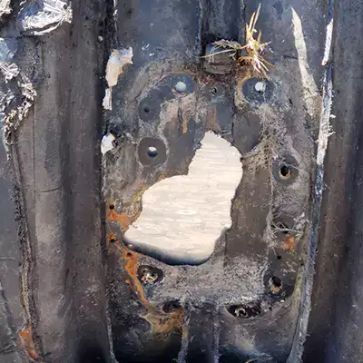 An exterior view of a damaged portion of HDPE, inside is a backing plate