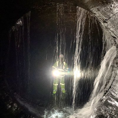 Water pouring into a pipe from the crown through a compromised joint